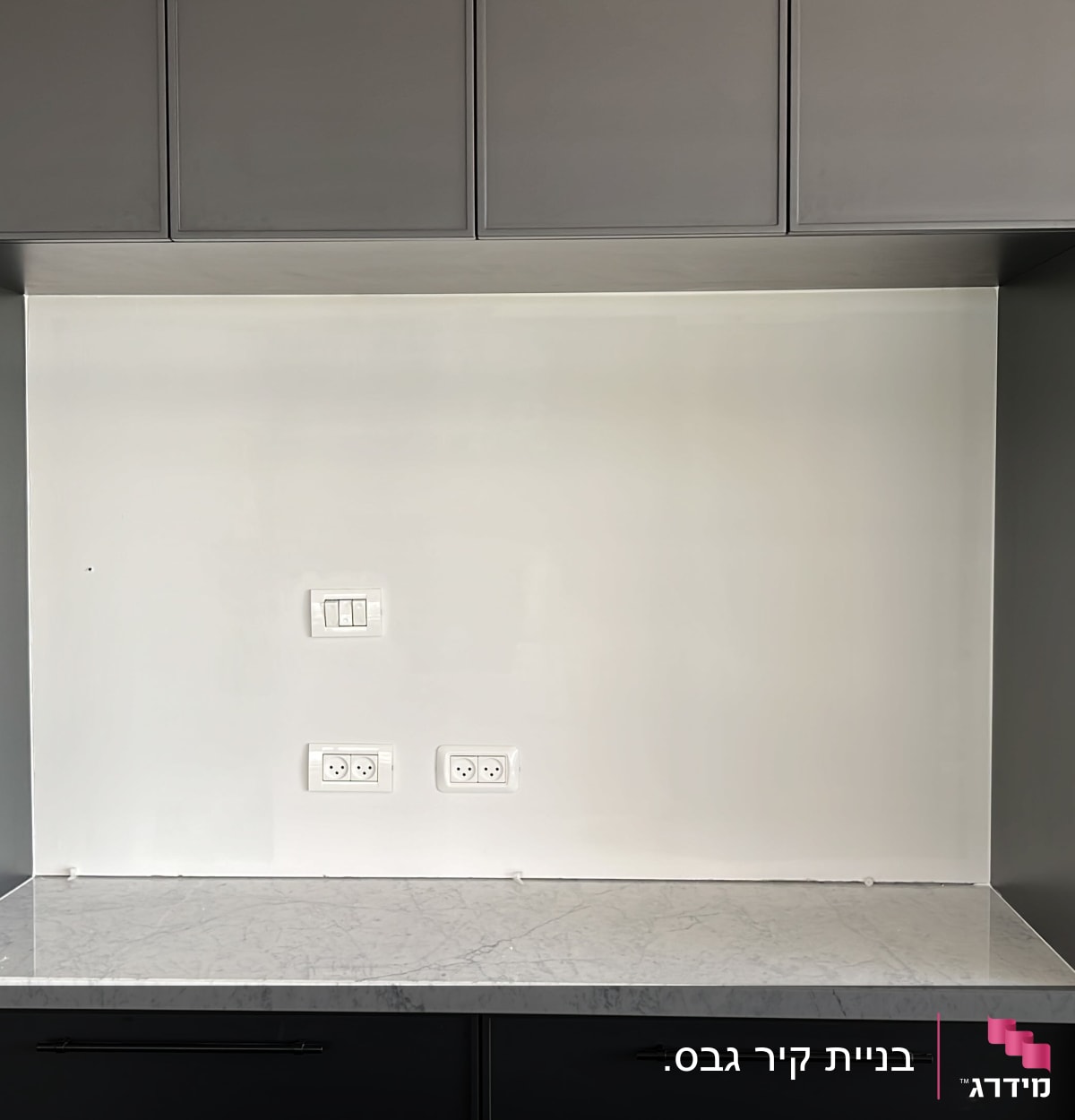 שקעי חשמל ומתגים על קיר לבן במטבח